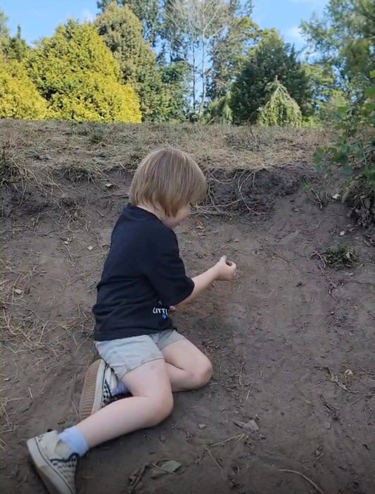 Young child playing in mud kitchen at Sunhouse outdoor summer camp, Vancouver